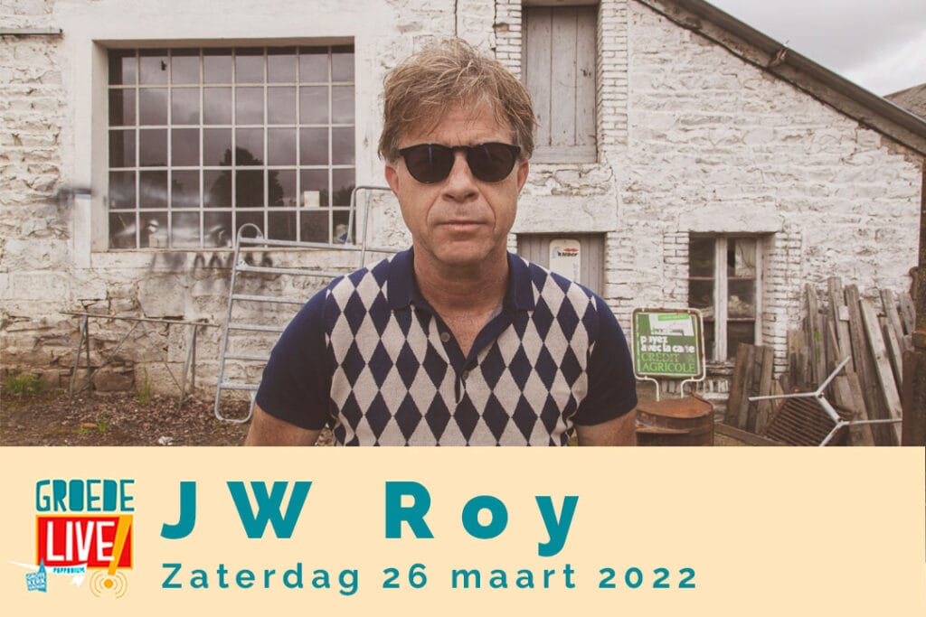 Promotieafbeelding voor Groede Live! met een portret van singer-songwriter JW Roy, die zonnebril draagt en kijkt in de camera. Hij staat voor een oude, witte stenen schuur. De tekst onderaan luidt: "Groede Live! J W Roy Zaterdag 26 maart 2022".